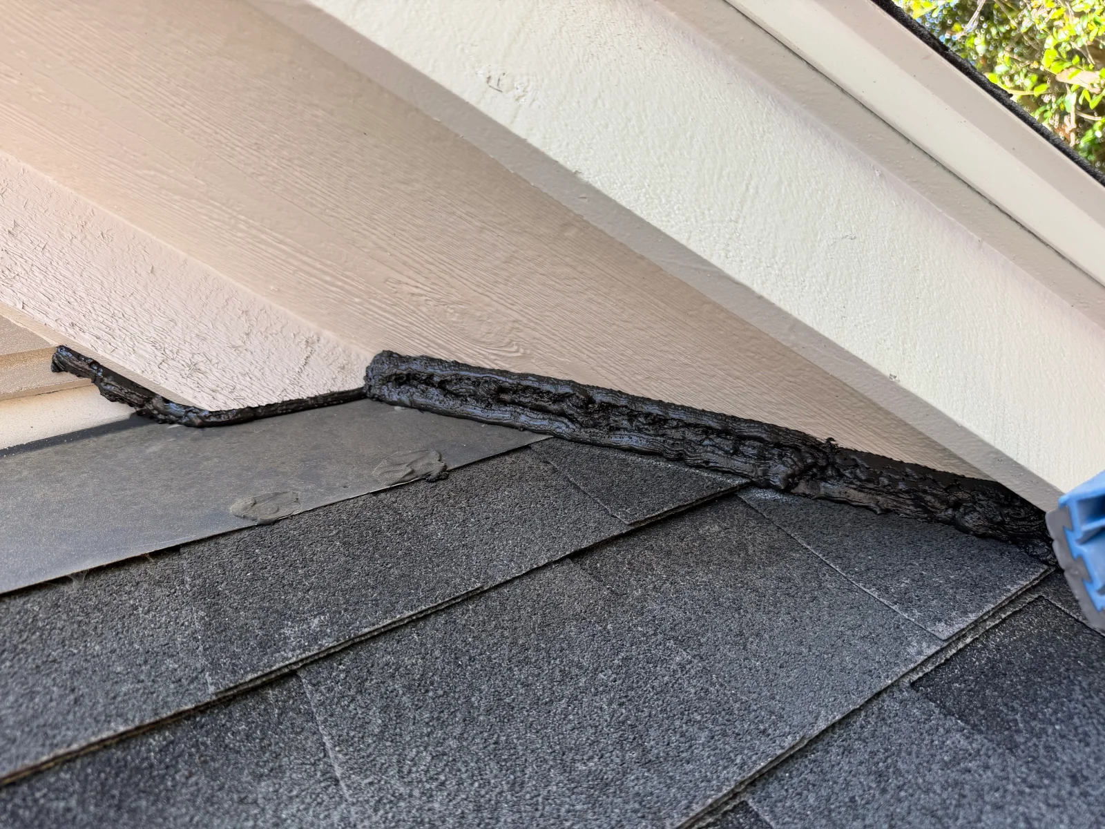 Damaged roof fascia and asphalt shingles with sealed wood trim at soffit line